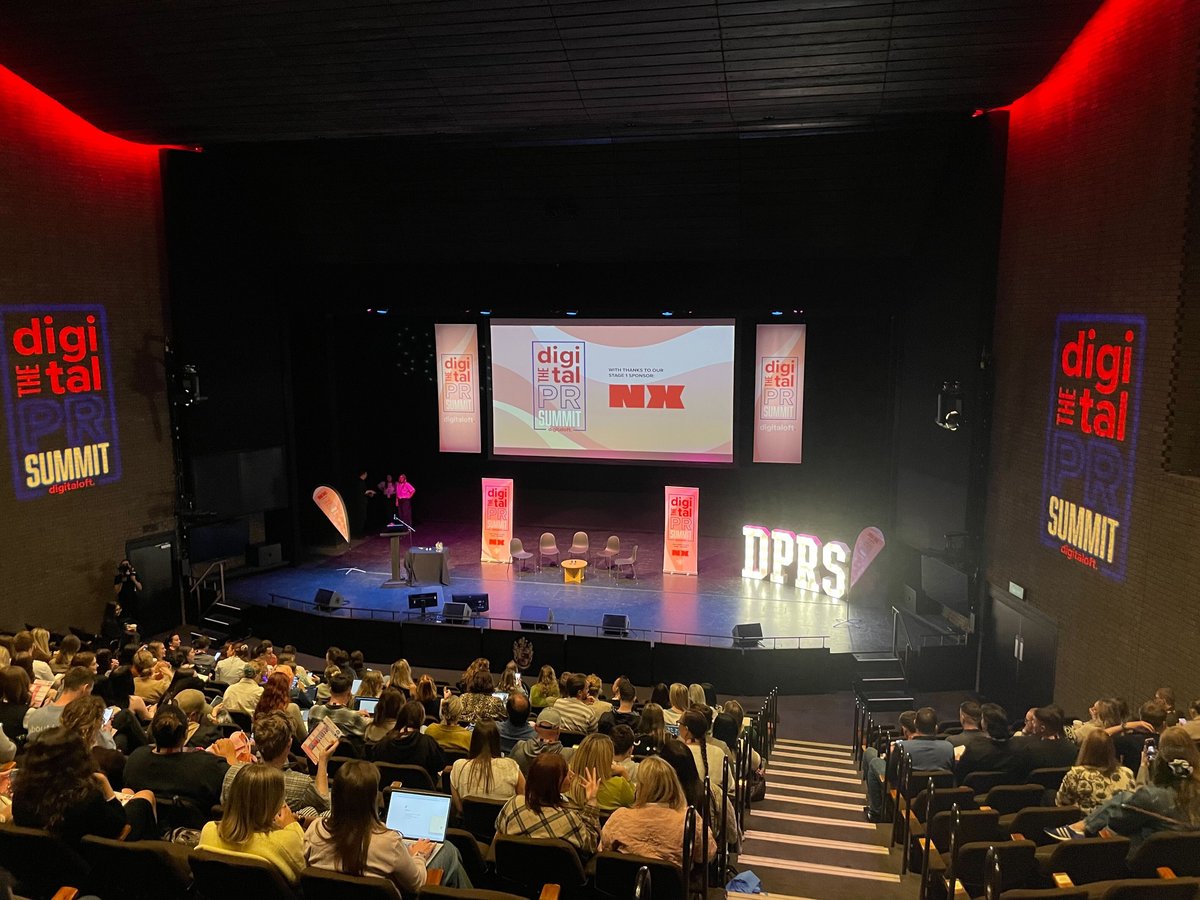 A photo from the audience of the stage area at the Summit