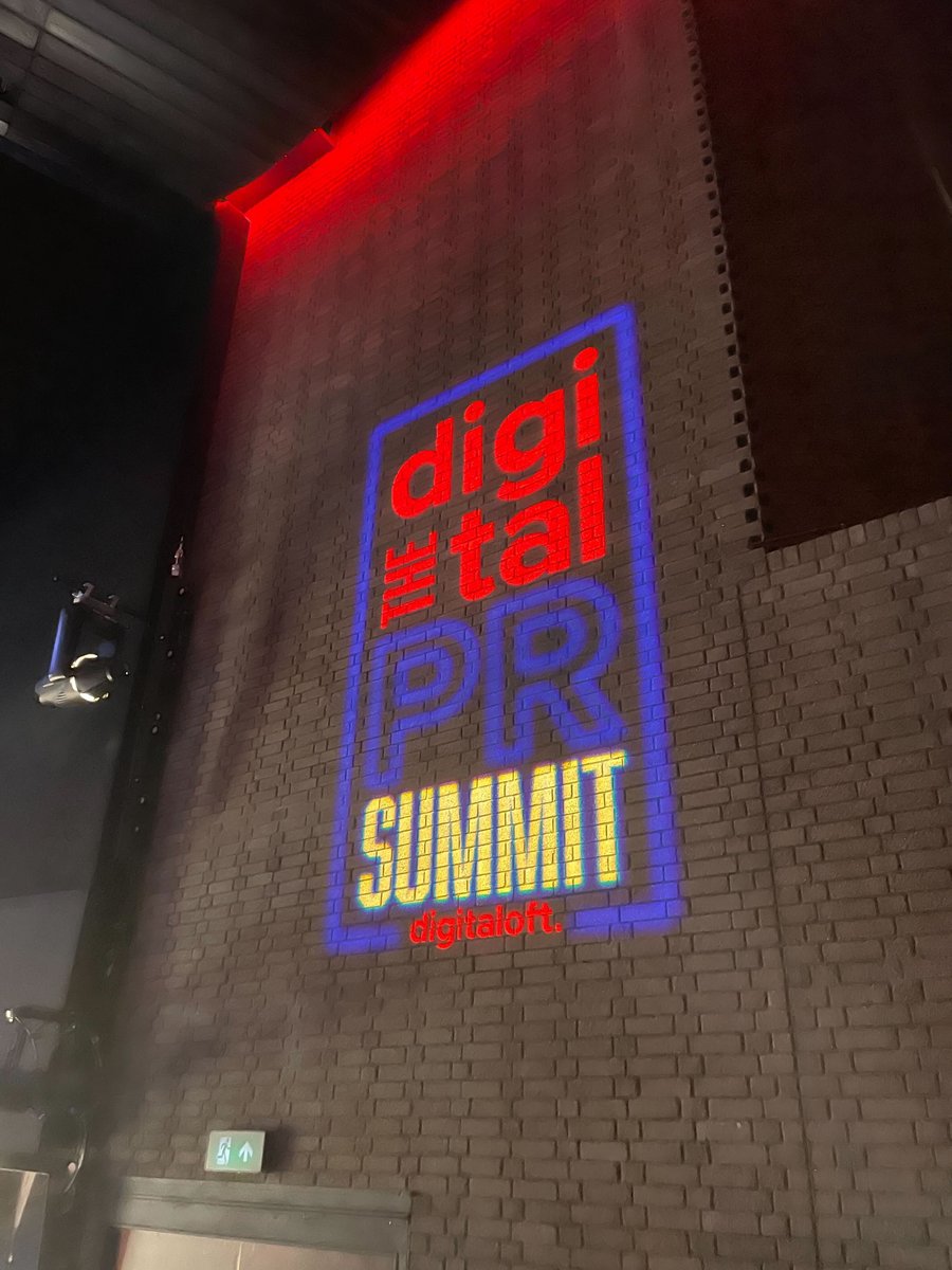 Logo for the Digital PR Summit 2025 projected onto a brick wall